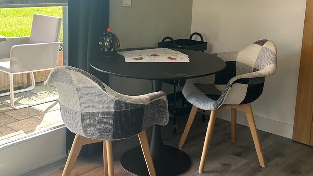 Ruokailutila, jossa on pyöreä pöytä, kaksi tuolia ja näkymä suuresta ikkunasta.