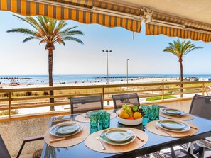 Ein Esstisch mit Blick auf Strand und Meer.