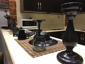 A kitchen counter with a microwave, a coffee maker, and a tea kettle. - Taleen Alsahafa Serviced Apartments (Riyadh)