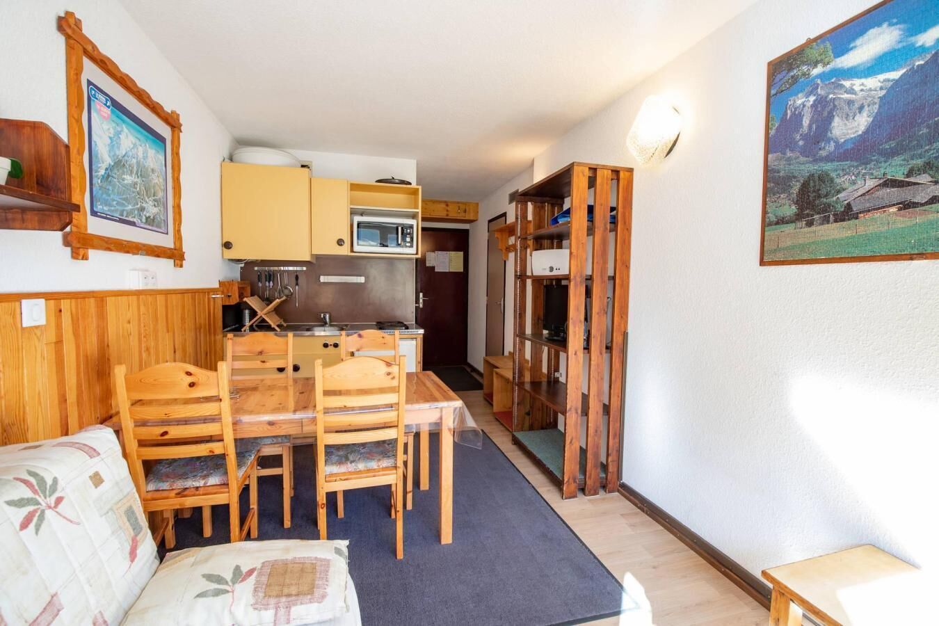 A compact living space with a dining area, kitchenette, and a small seating area.