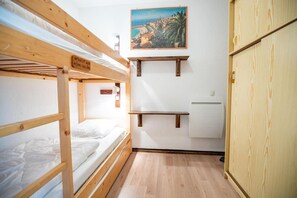 A bunk bed room with a painting on the wall, a shelf, and a wardrobe. - 250m from ski slopes, 2nd floor, balcony, tv, 23m², La Norma (La Norma)