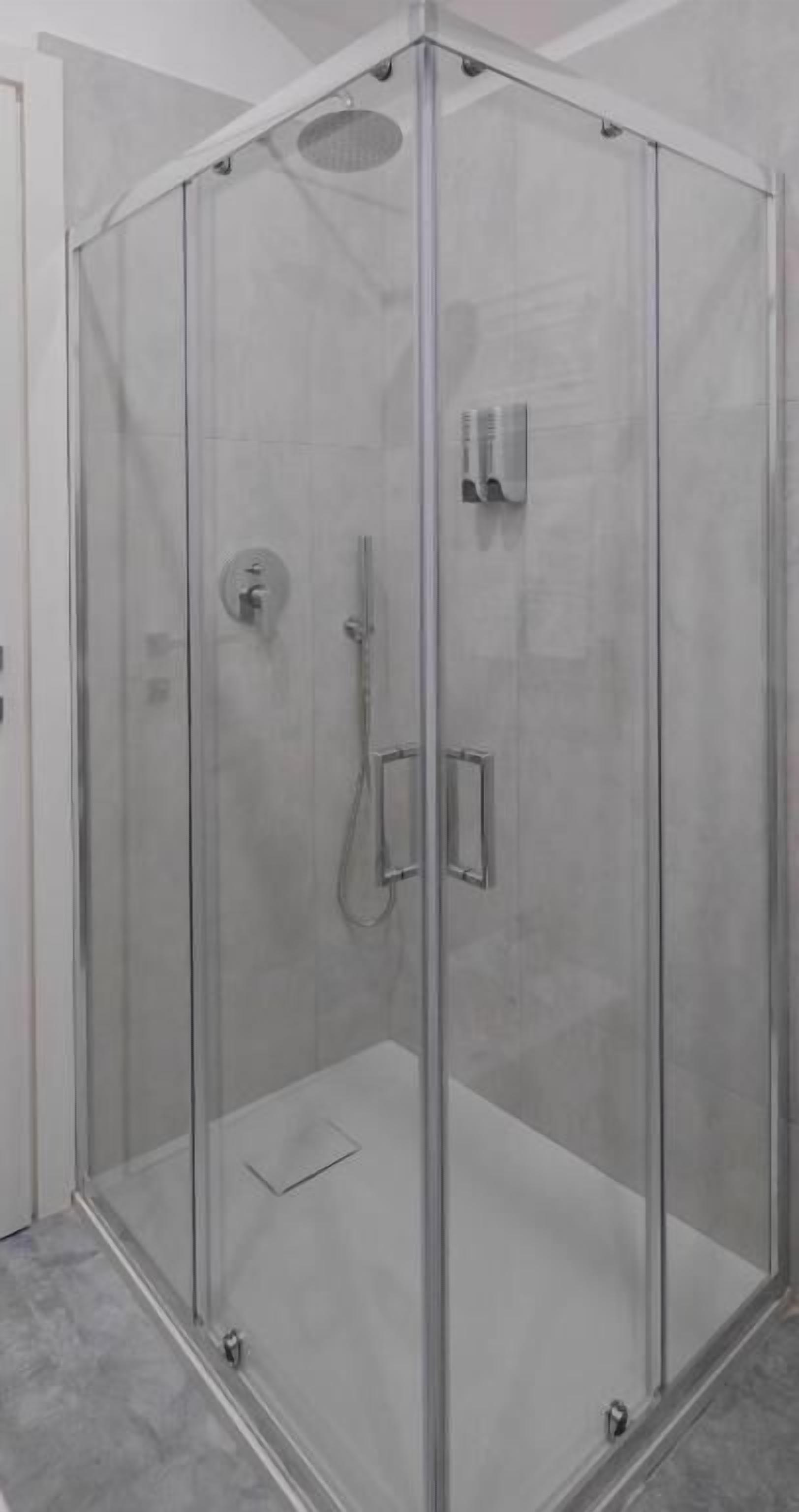 Une cabine de douche fermée par des parois en verre, équipée d’un pommeau de douche et d’un panneau de commande.