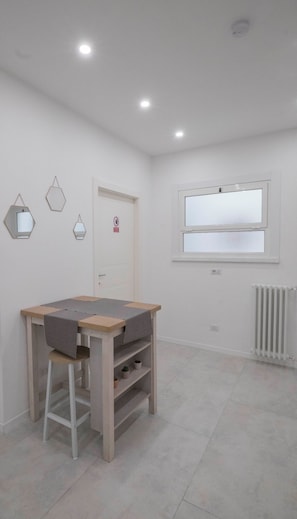 A room with a wooden desk, a stool, and a window with blinds. - IL PERUGINO GUEST HOUSE (Rome)