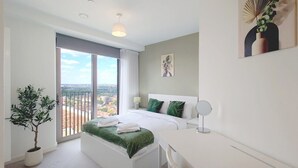 Una moderna camera d'hotel con un letto, un comodino e vista sulla città.