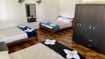 A hotel room with three beds, a wardrobe, a mirror, and decorative butterflies.
