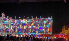 A large building with multiple levels and balconies, illuminated with colorful lights. - Apartment 5 minutes from the Nancy train station (Nancy)