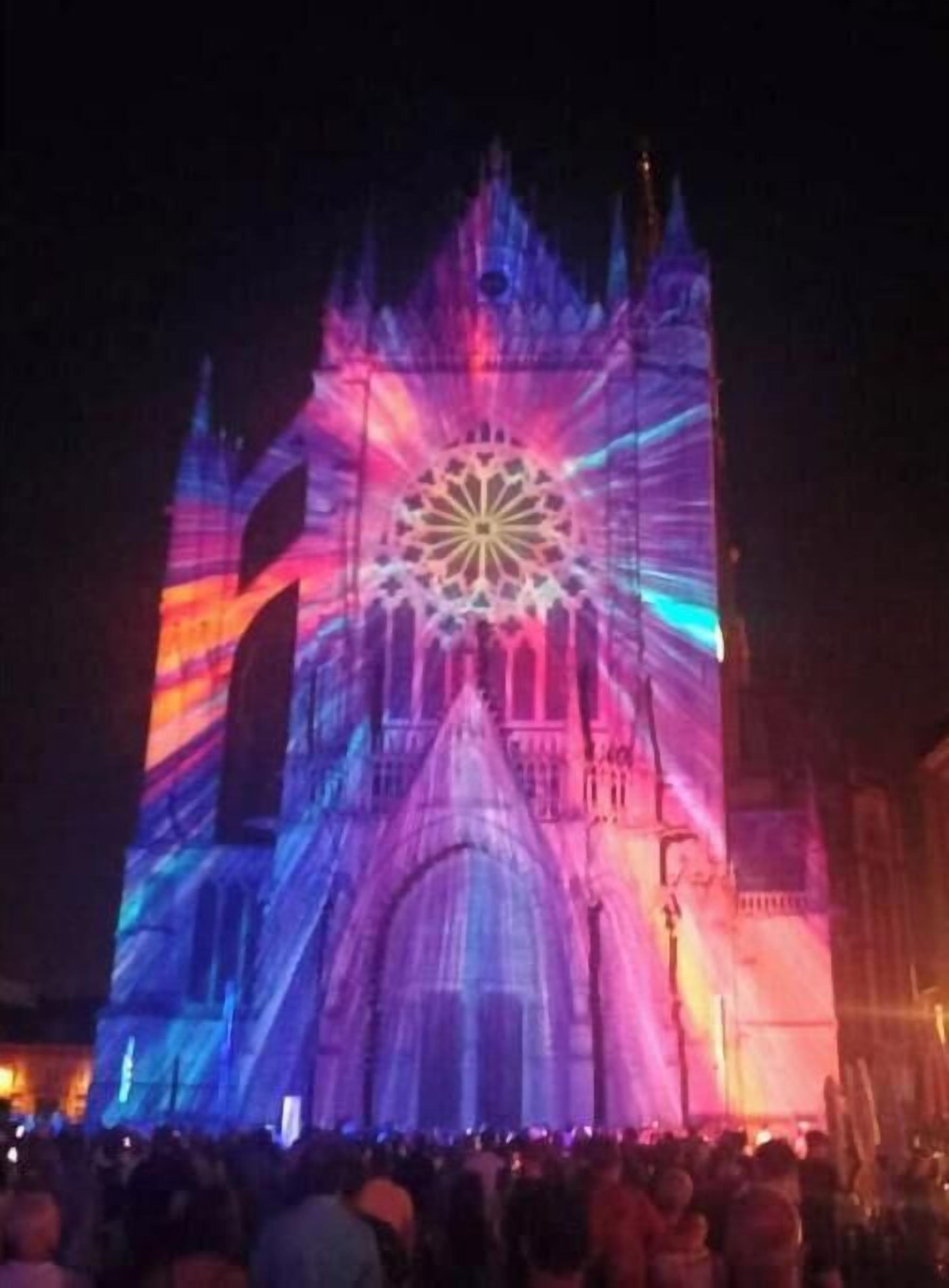 Una catedral grande con un rosetón destacado y una multitud de personas.
