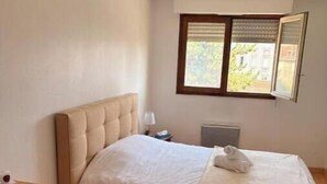 A bedroom with a bed, a dresser, a window with blinds, and a radiator. - Apartment 5 minutes from the Nancy train station (Nancy)