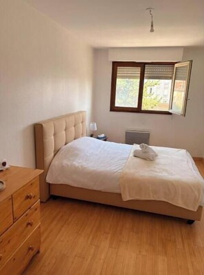 A bedroom with a bed, a dresser, a window with blinds, and a radiator. - Apartment 5 minutes from the Nancy train station (Nancy)