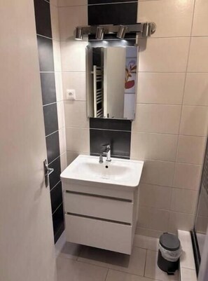 A bathroom with a white sink, a mirror, and a towel rack. - Apartment 5 minutes from the Nancy train station (Nancy)