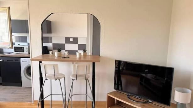 A modern kitchen with a microwave, a washing machine, and a checkered backsplash. - Apartment 5 minutes from the Nancy train station (Nancy)