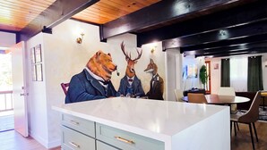 Una cucina moderna con una grande isola, soffitto in legno e lampade a parete.