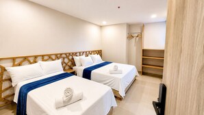 A hotel room with two beds, a wooden headboard, a built-in TV, and a small shelf. -  Hotel Azure Cartagena (Cartagena)