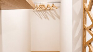A minimalist room with a wooden shelf, a metal rod with wooden hangers, and a wooden partition. -  Hotel Azure Cartagena (Cartagena)