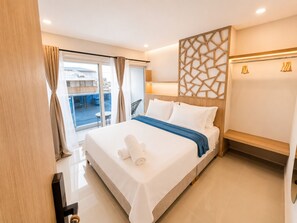 Habitación de hotel con cama, vista al exterior y un panel de madera.