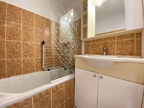 Un baño con bañera, cabina de ducha y tocador con espejo.