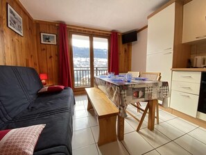 Una sala de estar acogedora con un sofá, una mesa de comedor y una zona de cocina.