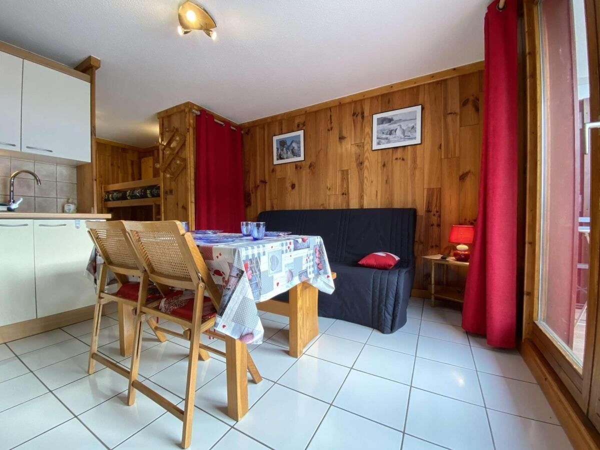 Un coin repas avec une table et des chaises, un canapé et, au fond, une cuisine.