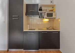 A compact kitchen with dark cabinets, a microwave, and a sink. - 200m from ski slopes, swimming pool, balcony, tv, ski locker, 24m², Les Orres (Les Orres)