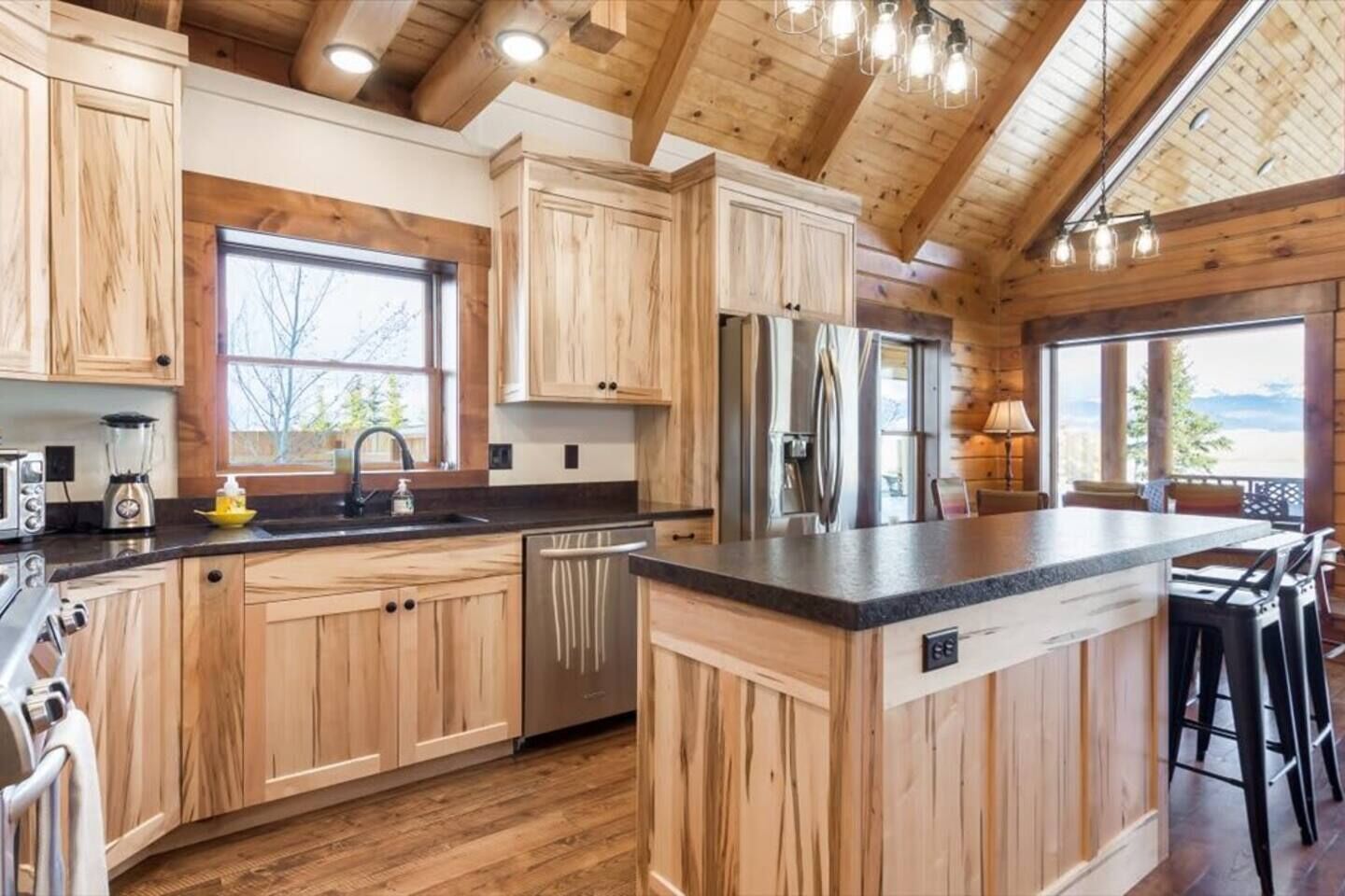 A kitchen with wooden cabinets, a central island, a refrigerator, and a dishwasher.