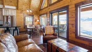 L’intérieur d’une cabine comprenant un coin repas, un canapé, un fauteuil et une table.