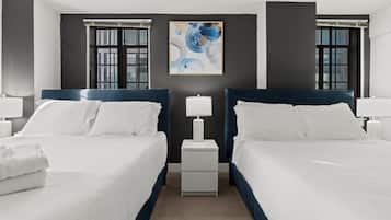 Une chambre d’hôtel avec deux lits, une table de chevet, une lampe et un tableau au mur.