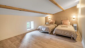 A bedroom with two beds, wooden beams, a window, and bedside lamps. - A Getaway to Les Granges: River 200 meters away on foot (Saint-Martin-d'Ardèche)