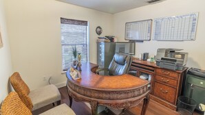 A room with a wooden desk, leather chair, and a filing cabinet. - THE CLAR by EVRH (Orlando)