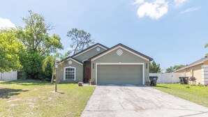 A single-story house with a garage, a front yard, and a mailbox. - THE CLAR by EVRH (Orlando)