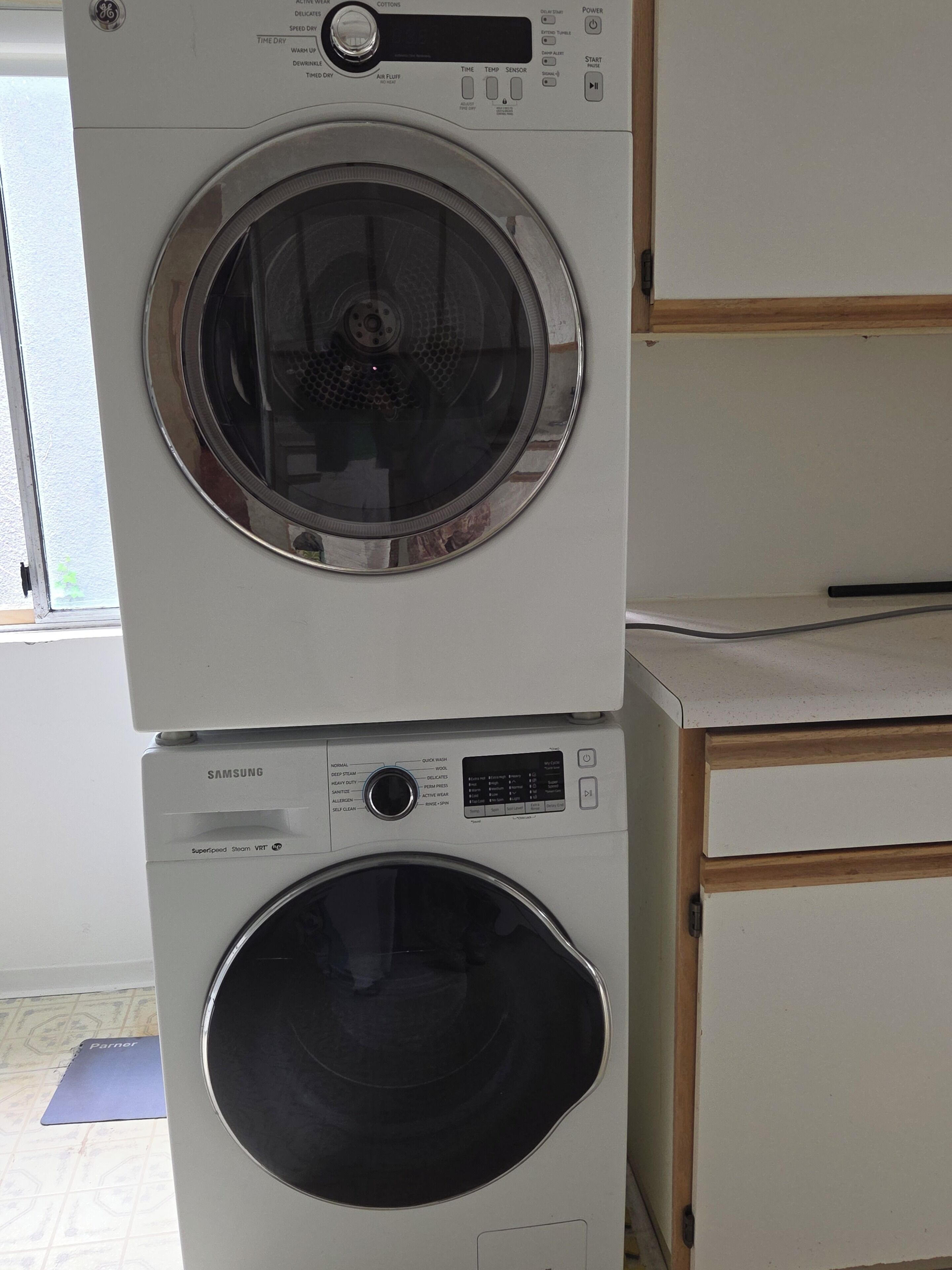 A stacked washer and dryer unit with a Samsung label, a control panel, and a door.