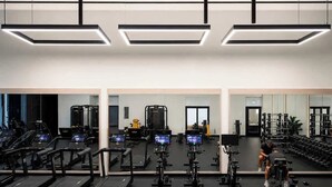 Academia com esteiras, máquinas de musculação e pesos livres.