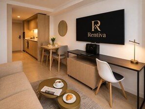 Una sala de estar moderna con un sofá, un comedor con mesa y sillas, una cocina al fondo y un gran letrero 'Rentiva' en la pared.
