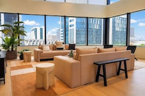 Una sala de estar moderna con un gran ventanal, un juego de sofá, una mesa de centro y una planta en maceta.
