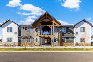 A multi-story building with a central wooden structure, stone facade, and multiple windows. - Teton Timber Nook - Targhee, Tetons, Jackson (Driggs)