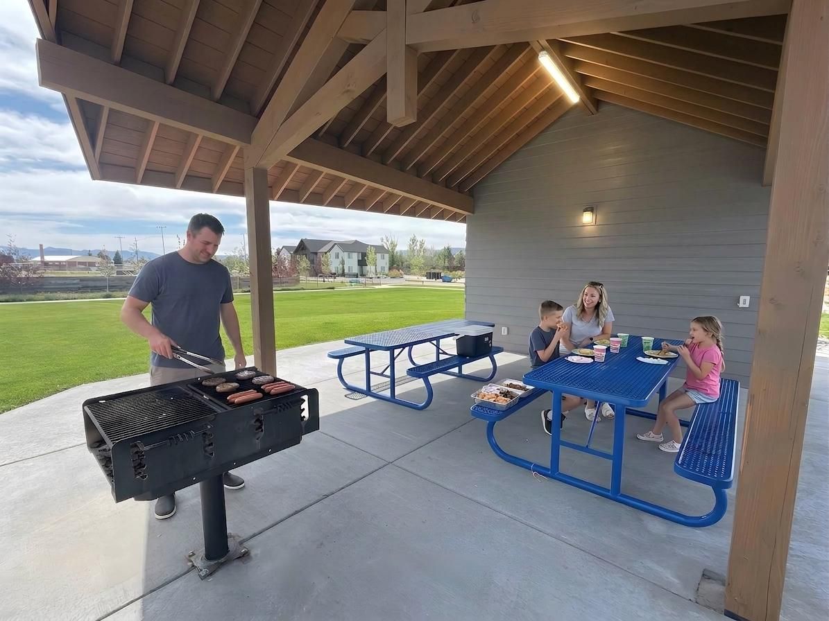En uteplats med en grill, picknickbord och en överbyggd sittplats.