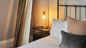 A hotel room with a bed, pillows, a nightstand, a lamp, and a mirror. - Host Stay Kingsley House (Saltburn-by-the-Sea)