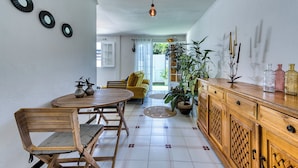 Un coin repas avec une table ronde, des chaises en bois et un meuble avec des tiroirs.