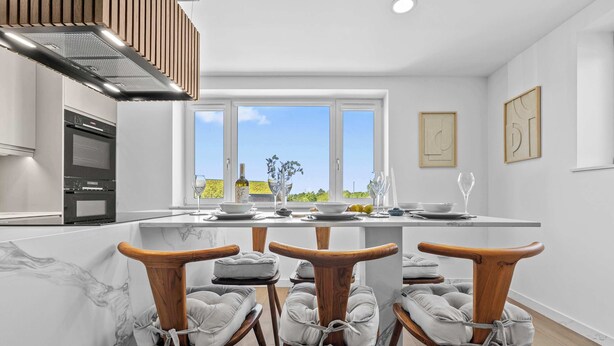 A modern kitchen with a central island, wooden chairs, and a view of the outdoors. - 3BR Cosy & Chic House, Guildford Festival Offer! (Gulidford)