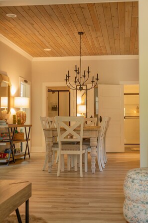 A dining area with a wooden ceiling, a chandelier, and a white dining table with chairs. - Laid-back, luxurious 4-bed, 2-bath home, 10-minute walk to downtown Saugatuck (Saugatuck)