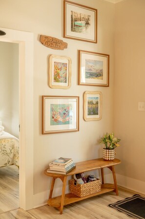 A hallway with a wooden console table, a potted plant, and framed artwork on the wall. - Laid-back, luxurious 4-bed, 2-bath home, 10-minute walk to downtown Saugatuck (Saugatuck)