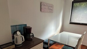 A small kitchen with a coffee maker, a kettle, and a sign on the wall. - Find peace and discover yourself (Hürtgenwald)