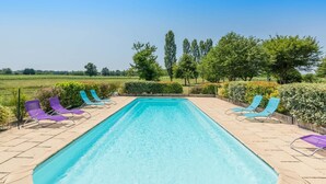 A rectangular swimming pool with clear blue water, surrounded by a tiled deck. - Petit Gite de la Mondette (LES-SALLES-DE-CASTILLON)