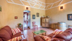 A spacious living area with leather sofas, a wooden cabinet, and a tiled floor. - Petit Gite de la Mondette (LES-SALLES-DE-CASTILLON)