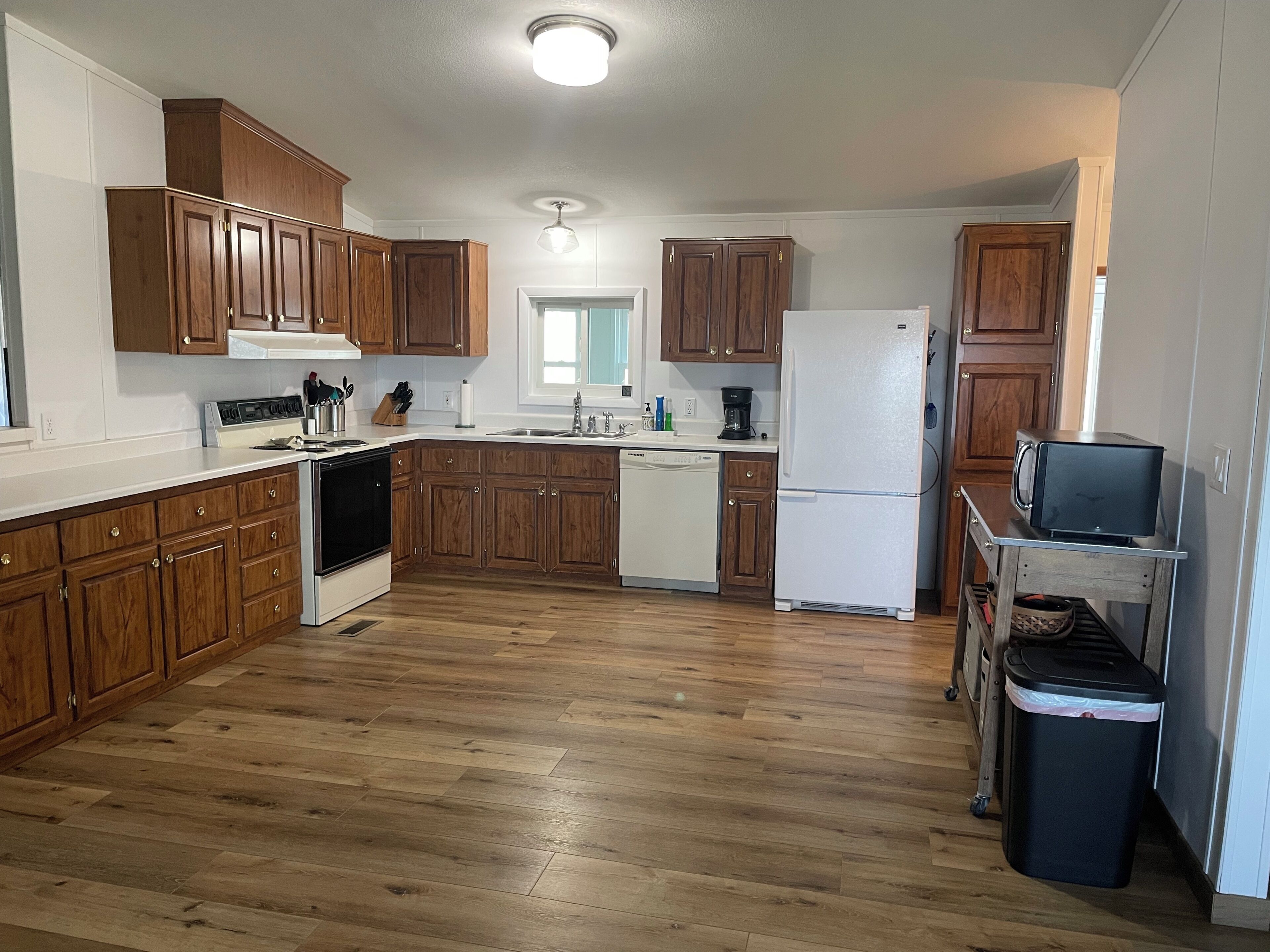 A kitchen with wooden cabinets, a white refrigerator, a stove, and a microwave.