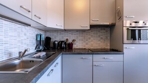 Een moderne keuken met een roestvrijstalen spoelbak, een koffiezetapparaat en een afzuigkap.