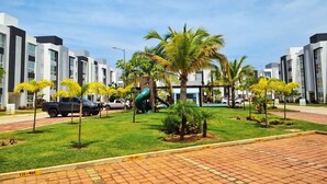 A modern building with a playground, palm trees, and a clear sky. - Perfect 2-bedroom apartment with AC in lovely Acapulco de Juárez (Acapulco de Juárez)