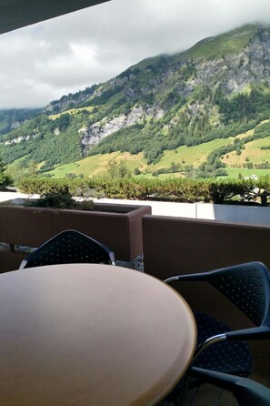 A table and chairs with a view of a mountainous landscape. - Lärchenwald 1708 # 5-bed apartment, Bad, WC 5-bed apartment, Bad, WC by Interhome (Leukerbad)