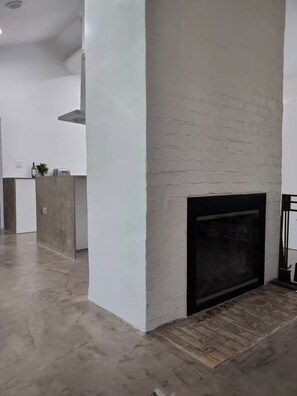 Un intérieur moderne avec une cheminée, un coin cuisine et un grand espace ouvert.
