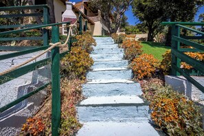 Una escalera de piedra con barandillas verdes que conduce a la entrada de un edificio.