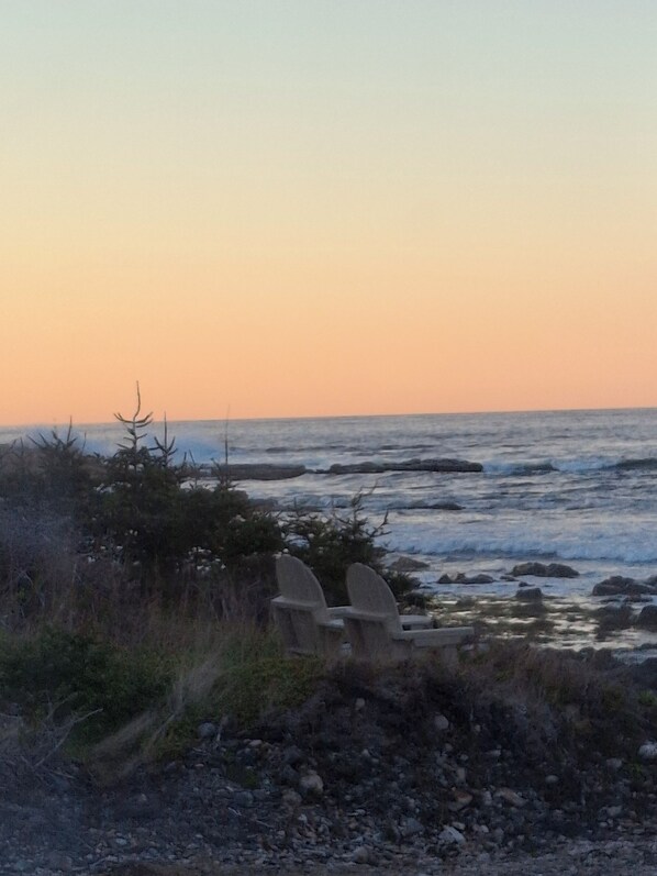 A coastal scene with two chairs facing the ocean, surrounded by rocky terrain and sparse vegetation. - "Oceanfront Cottage Rental"
Route 235 Bonavista Bay,NL (Hodderville)